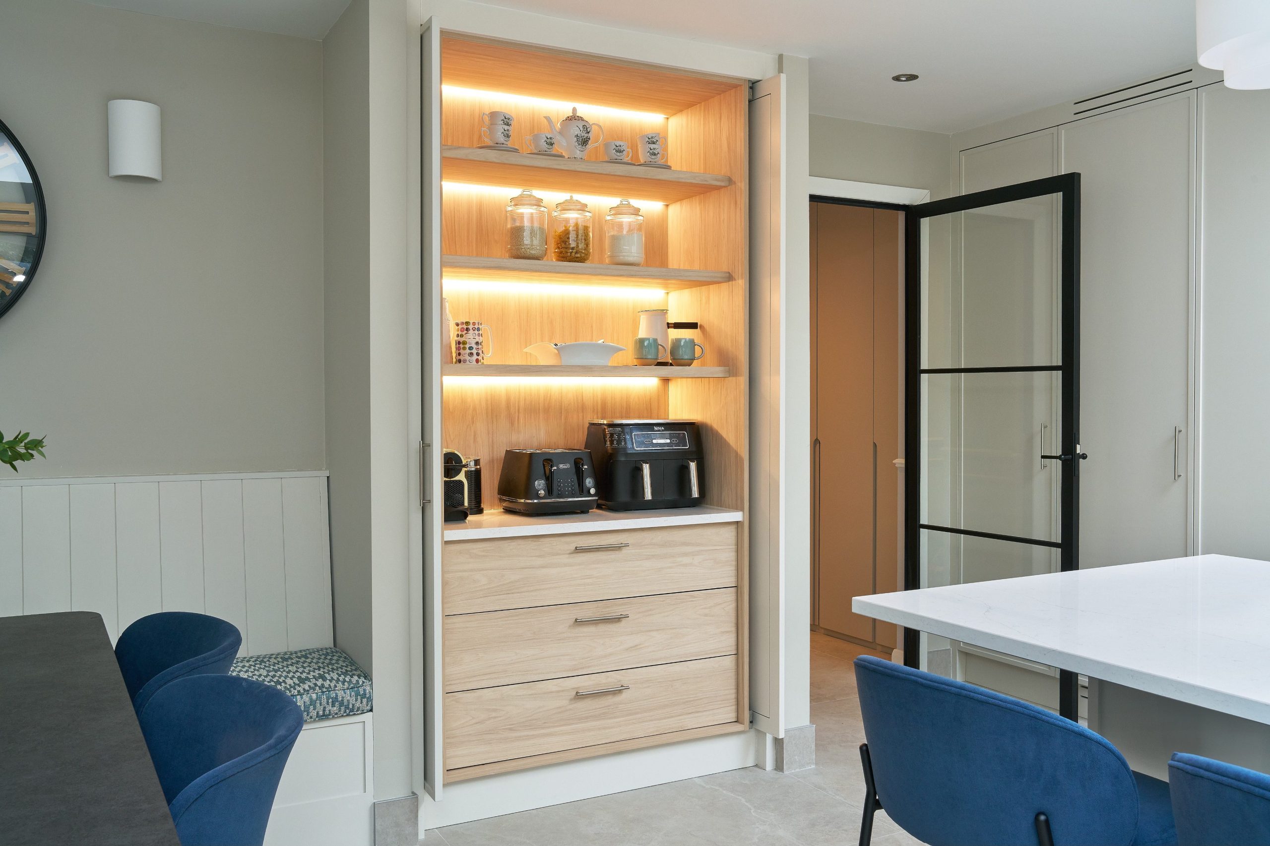 Built-in oak larder cabinet with LED-lit shelves, drawers and concealed appliance storage