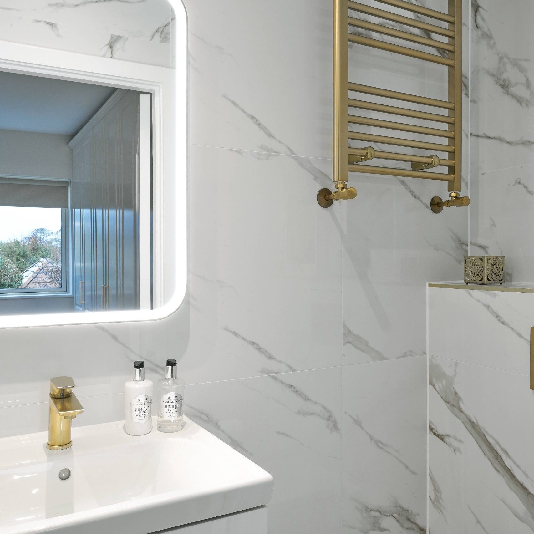 Bathroom with white stone walls & gold accents