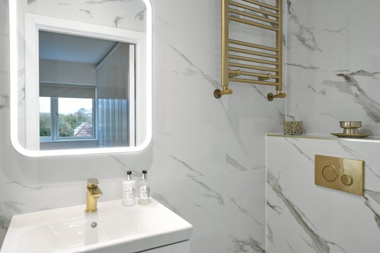 Bathroom with white stone walls & gold accents