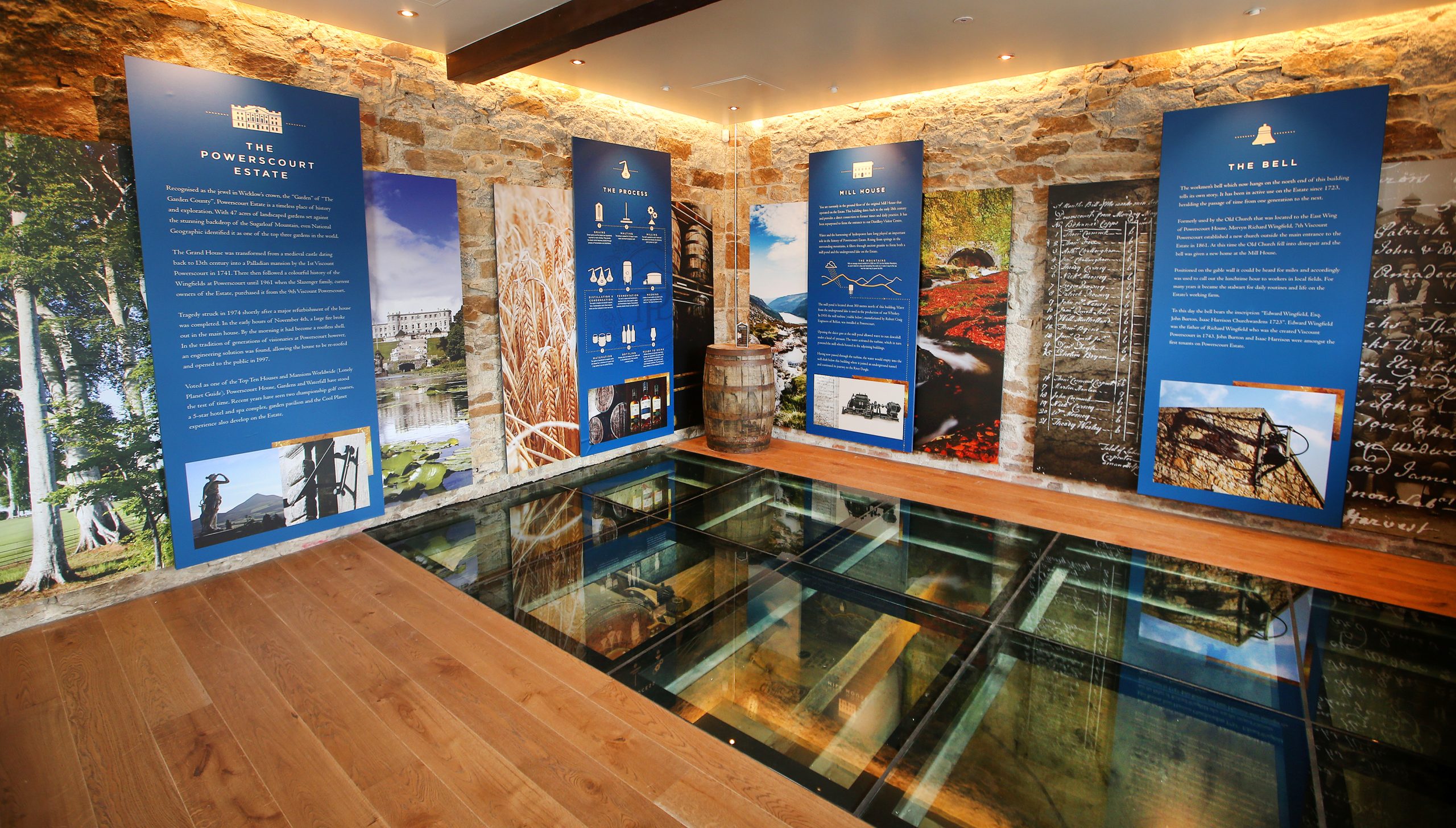 Powerscourt Estate exhibit with displays on the estate's history, process, mill house, and the bell, viewed through a glass floor.