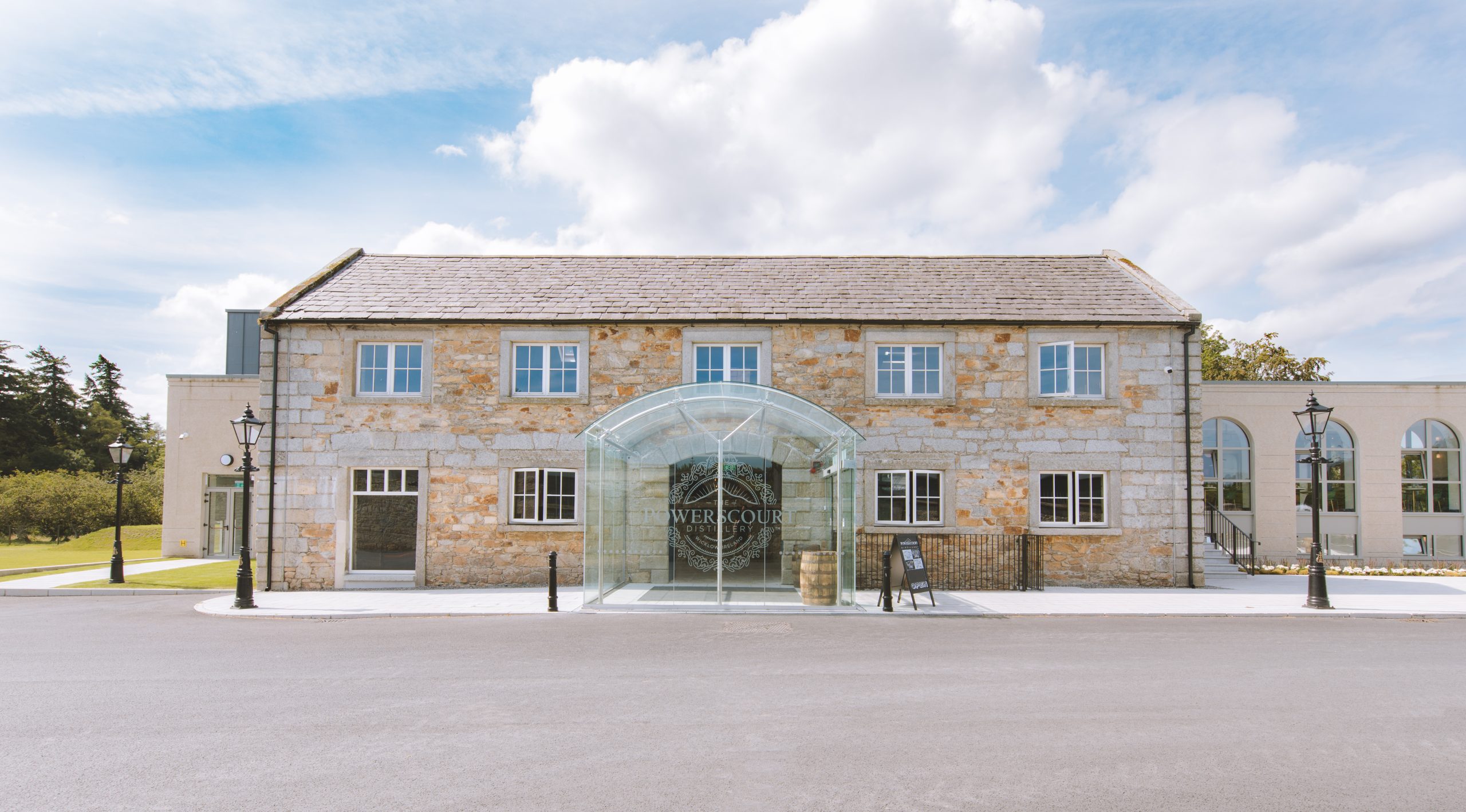 Powerscourt Distillery entrance with curved glass awning and stone facade