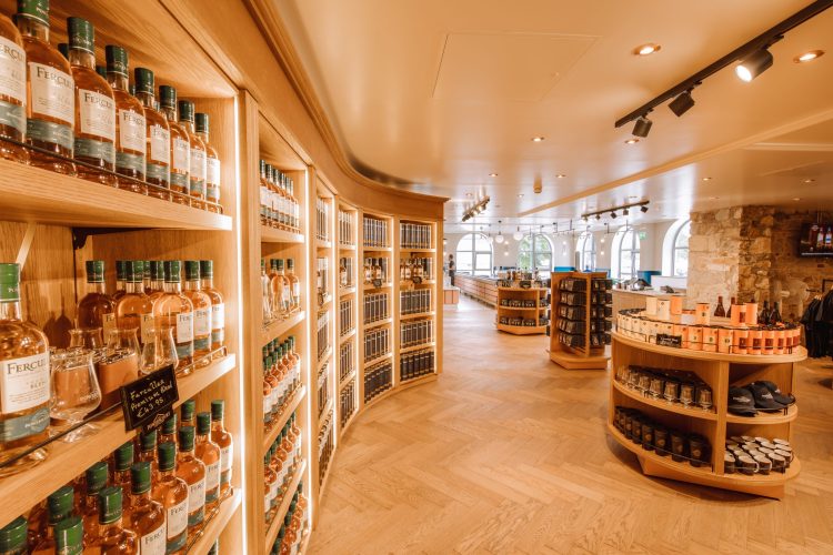 Powerscourt Distillery visitor center interior with whiskey bottles displayed on shelves.