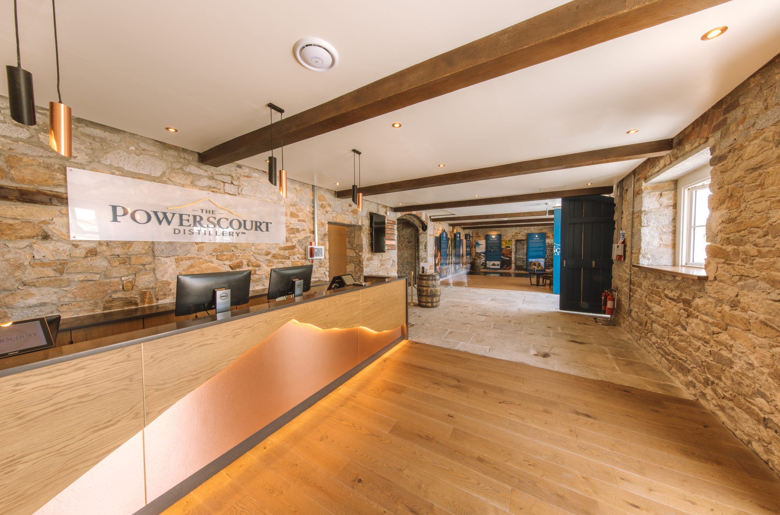 Powerscourt Distillery reception area with stone walls and wood accents.