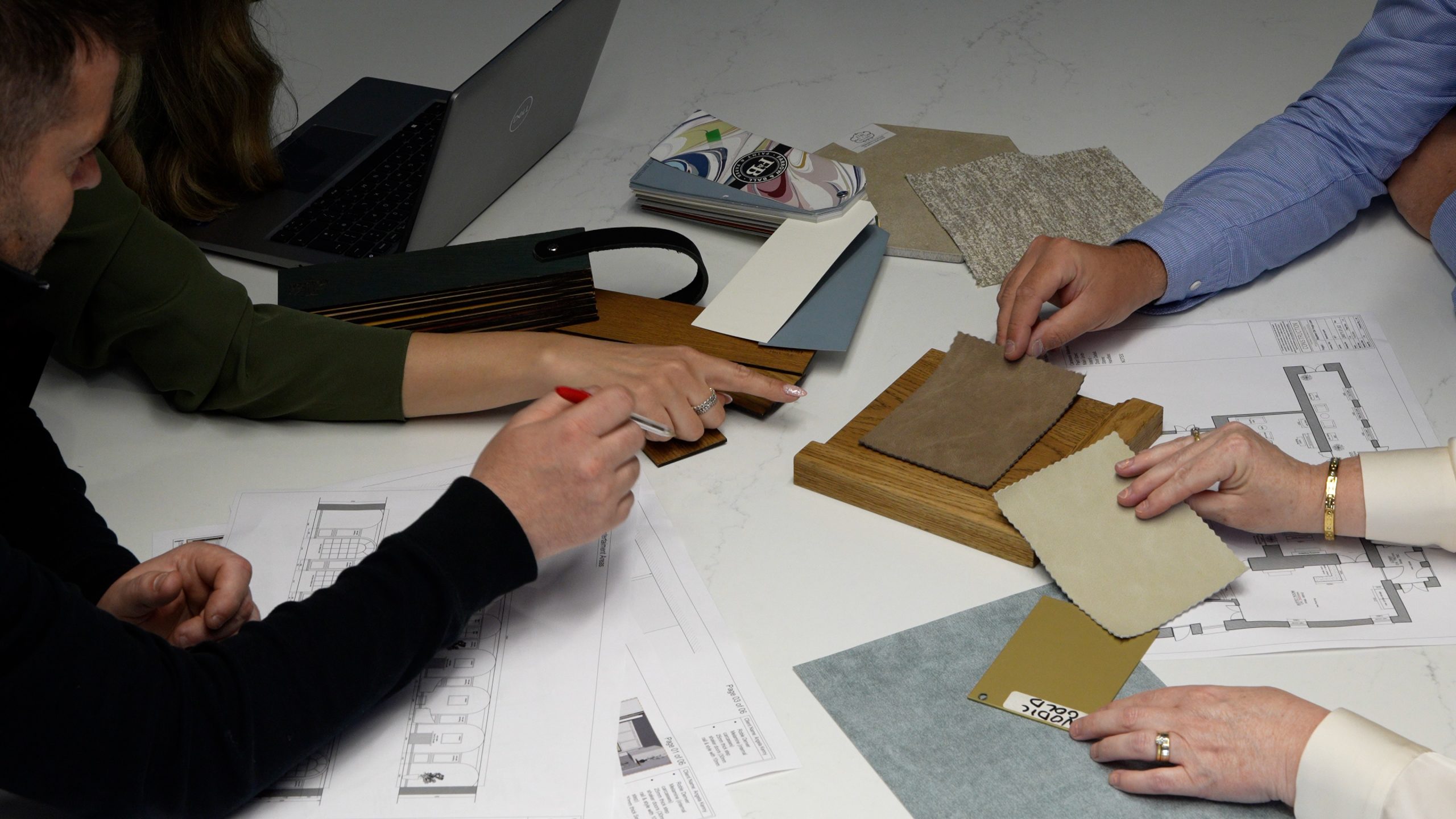 ONOVO commercial fit-out planning: a team reviewing blueprints and material samples on a table
