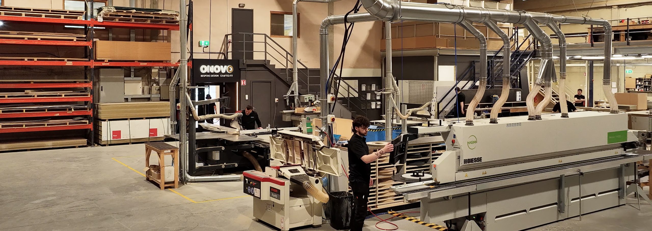 ONOVO woodworking factory floor with a Biesse machine and craftspeople manufacturing bespoke joinery