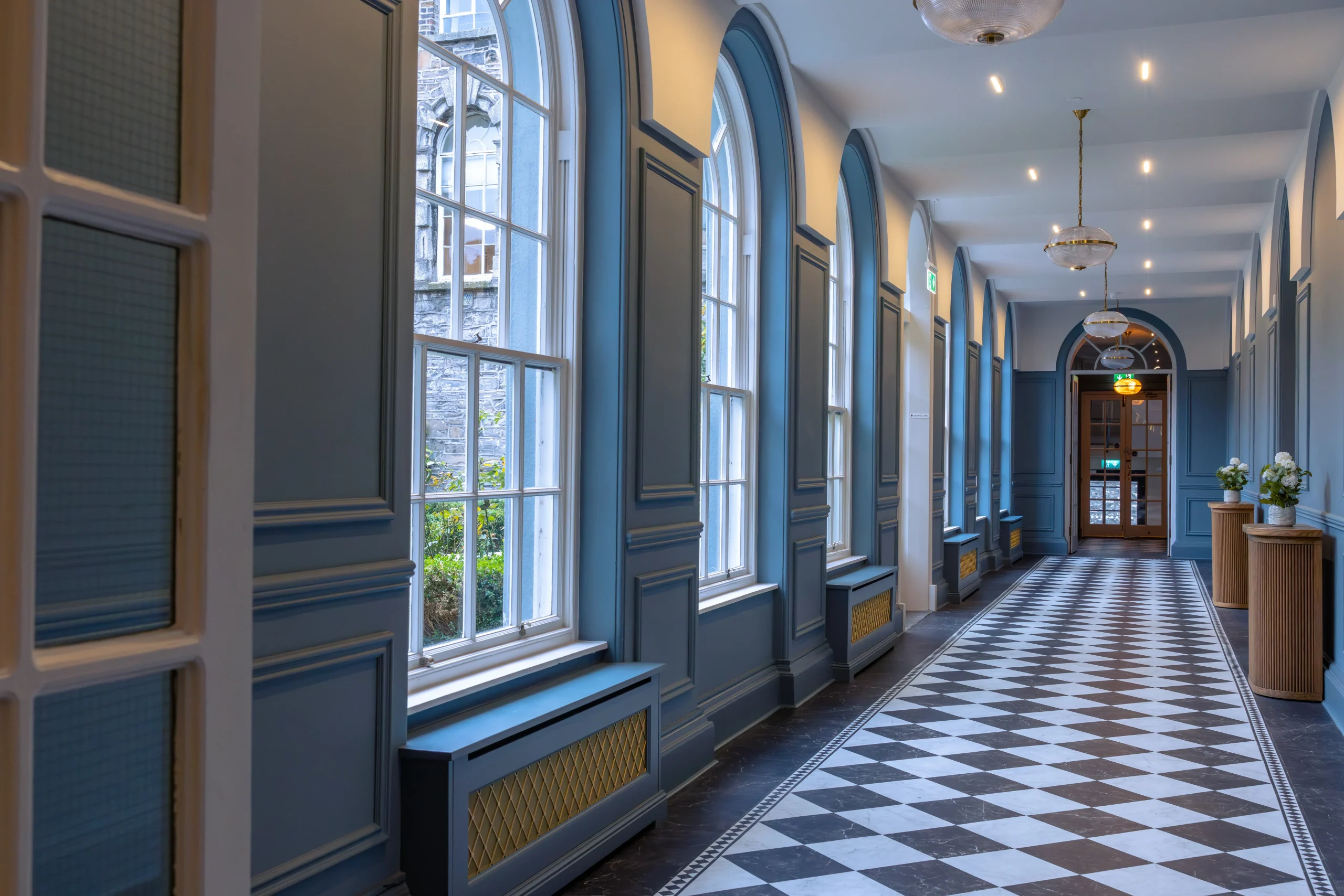 Law Society Dublin office hallway fit-out with blue panelled walls, arched windows and bespoke joinery